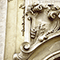 Bassorilievo che allude all'osservazione dei satelliti di Giove per determinare la longitudine in mare sulla facciata del Palazzo dei Cartelloni, Firenze.