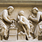 Tabernacolo dei Santi Quattro Coronati, particolare del bassorilievo raffigurante due santi al lavoro: uno, con compasso e squadra, realizza un capitello, mentre l'altro scolpisce un putto con un picconcello o picchiarello, Nanni di Banco, 1408, Orsanmichele, Firenze.