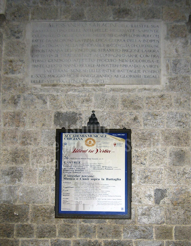 Lapide e cartellone pubblicitario sulla facciata dell'Accademia Musicale Chigiana, Siena.