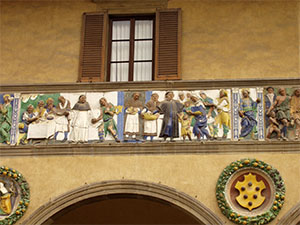 "Dare da mangiare agli affamati", fregio policromo robbiano sull'antica facciata dello Spedale del Ceppo, terracotta invetriata, Santi Buglioni, 1526-28, Pistoia.