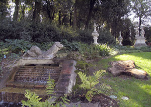 Giardino di Palazzo Mozzi Bardini a Firenze: giochi d'acqua e statue nel prato del bosco inglese.