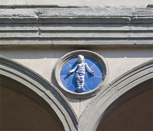 Ceramica raffigurante un bambino in fasce sulla facciata dell'Ospedale degli Innocenti, Firenze.