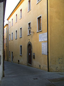 Faade of town hall of Campiglia Marittima, on which appears a table of conversion for measurements.
