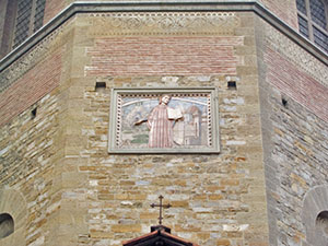 Bas-relief on the Palazzo of the Wool Merchants Guild depicting Dante.  In the background, note the Walls of Florence and several major buildings, including Brunelleschi's Dome and the tower of Palazzo Vecchio.