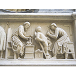 Tabernacolo dei Santi Quattro Coronati, particolare del bassorilievo raffigurante due santi al lavoro: uno, con compasso e squadra, realizza un capitello, mentre l'altro scolpisce un putto con un picconcello o picchiarello, Nanni di Banco, 1408, Orsanmichele, Firenze.