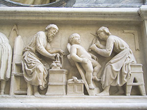 Tabernacle of the Four Crowned Saints, detail of the bas-relief depicting two saints at work:  one, with a compass and square, makes a capital, while the other sculpts a putto with a pick or mattock, Nanni di Banco, 1408, Orsanmichele.