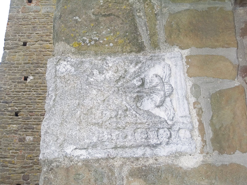 Calco di urna funeraria etrusca sulla facciata della Pieve di S. Leonardo ad Artimino.