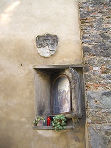 Coat of arms and tabernacle on the side-wall of the Torrigiani Garden on Via del Campuccio, Florence.